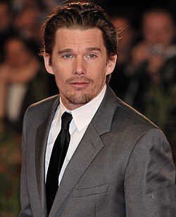 Hawke wearing a suit and tie, looking slightly away from the camera