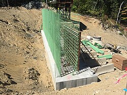 A construction site with a halfway built concrete structure