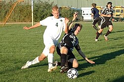A player executing a slide tackle to dispossess an opponent