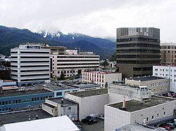 The center of state government in Juneau. The large buildings in the background are, from left to right: the Court Plaza Building (known colloquially as the "Spam Can"), the State Office Building (behind), the Alaska Office Building, the John H. Dimond State Courthouse, and the Alaska State Capitol. Many of the smaller buildings in the foreground are also occupied by state government agencies.