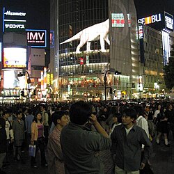 The walking dinosaur advertisement visible on the QFRONT (Tsutaya) building seen in the 2003 film Lost in Translation[17]