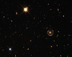 This blue horseshoe is a distant galaxy that has been magnified and warped into a nearly complete ring by the strong gravitational pull of the massive foreground luminous red galaxy.