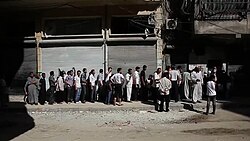 Aleppo residents waiting in a bread line during the Syrian civil war
