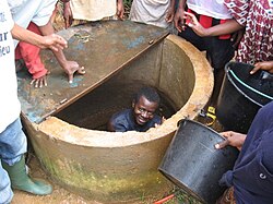 Man cleaning a well in Yaoundé, Cameroon