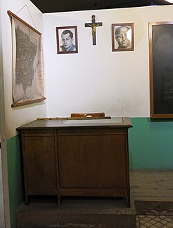 A recreation of a typical classroom from the Franco era, featuring a crucifix and portraits of Franco (on the right) and José Antonio Primo de Rivera (on the left). Taken at the Museum of the History of Catalonia.