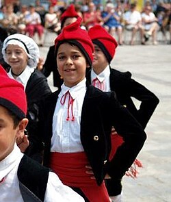 Catalan children wearing the traditional outfit, including the barretina