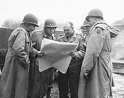 From left to right: Major General Leven C. Allen, Lieutenant General Omar Bradley, Major General John S. Wood, Lieutenant General George S. Patton and Major General Manton S. Eddy being shown a map by one of Patton's armored battalion commanders during a tour near Metz, France, November 1944