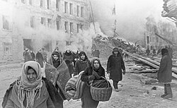 Russian civilians leaving destroyed houses after a German bombardment during the siege of Leningrad (Saint Petersburg), 10 December 1942