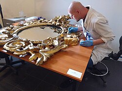 Restoration of a gilded mirror by a conservator