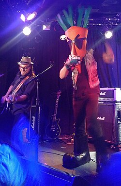 Lead singer Carrot Topp (pictured with The Dickies's Stan Lee in 2018) has been the band's sole constant member since forming the Chicken Heads in 1993.