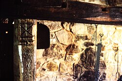 Traditional stone fireplace in northern England. The carved Saint Andrew's cross in the left-hand wooden post was to prevent witches from flying down the chimney, in Ryedale Folk Museum, Hutton-le-Hole.