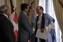 A photograph of Hugo Martínez shaking hands with Sueilima Tieb Ahmed Salem