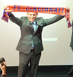 Garber holds up an FC Cincinnati scarf during his 2016 visit to Cincinnati.