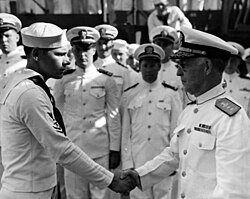 Rear Admiral Ernest G. Small (right) presents Purple Heart medals to enlisted men wounded in the Pearl Harbor attack