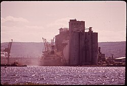 Dust fills the air as ships are loaded from a Cargill grain elevator in Duluth, Minnesota, 1973