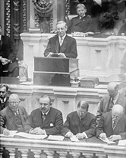 Wilson giving his first State of the Union address in 1913 before a joint session of Congress,[122] which initiated the modern practice of the State of the Union being given in person before all members of Congress[123]