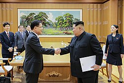 Kim (holding envelope) with Chung Eui-yong. Kim's sister Kim Yo Jong (on the right) is said to be very close to him.