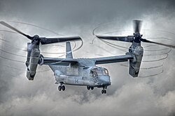 V-22 with rotors tilted, condensation trailing from propeller tips