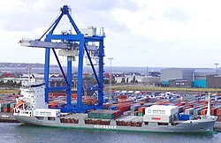 A container ship being loaded by a portainer crane in Copenhagen Harbor, Denmark.