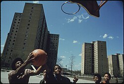 African-American youths play basketball in Chicago's Stateway Gardens high-rise housing project in 1973.