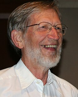 Photo of a bearded man with short gray hair wearing glasses