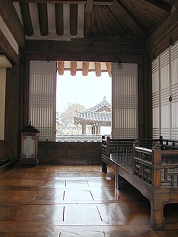 A Numaru is a traditional Korean balcony-like raised veranda. It is often distinguished from a larger living room by a plinth, a partial enclosure, and low-to-the-floor furniture.