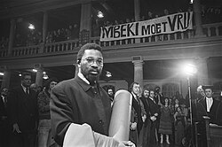 Mbeki's brother Moeletsi in Amsterdam in 1978, accepting an award on behalf of their father. The banner calls for Govan's release.