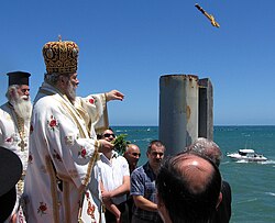 Greek Orthodox bishop at the Great Blessing of Waters on Theophany, releasing the cross off the Glenelg Jetty, South Australia, for one of the swimmers below to retrieve