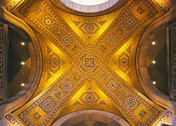 The mosaic ceiling of the rotunda is covered predominantly in gold back-painted glass tiles with different cultural symbols related to exhibits in the museum in Byzantine style
