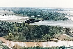 U.S. Army helicopter spraying Agent Orange over agricultural land during the Vietnam War