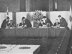 Korean and Japanese diplomats on June 22, 1965, signing the treaty.