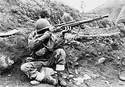 A soldier of the Dutch detachment of the UN forces in North Korea prepares to return sniper fire, 1952