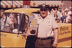 Parking meter checker stands by his police vehicle in 1974, which is imprinted with the German word for police (Polizei), part of the town's highlighting its German ethnic origins. Photo by Flip Schulke.