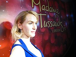 Madame Tussauds logo (spelled without the apostrophe) next to a waxwork of Kate Winslet in London