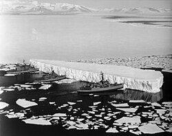 An iceberg being pushed out of a shipping lane by (L to R) USS Burton Island, USS Atka, and USS Glacier near McMurdo Station, Antarctica, 1965