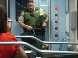 A LASD deputy and a police dog patrol a LA Metro light rail train