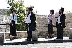 Two Haredi Jewish couples at a bus stop in Jerusalem
