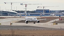 Finnair Airbus A319 at the Helsinki Airport in Vantaa, Finland. Terminal expansion construction site in the background.