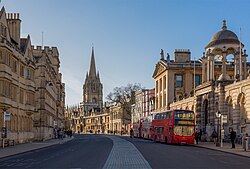 High Street in Oxford, England, a prototypical example of a university town. There is no central campus; rather, university buildings are scattered around the city between shops, such as those at centre right of the picture.