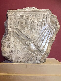 Alabaster relief depicting Akhenaten under the rays of the Aten. He wears a tall crown topped with rams horns, a solar disc, and two tall feathers. Displayed in the Egyptian Museum, Cairo.
