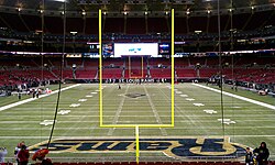  Photograph of a football field taken from the end zone showing goal posts in the foreground