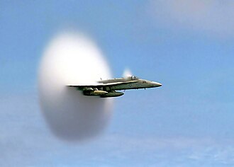 U.S. Navy F/A-18 approaching the speed of sound. The white cloud forms as a result of the supersonic expansion fans dropping the air temperature below the dew point.[1][2]