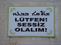A warning sign in Mardin, Turkey: Syriac Turkish ܫܬܩܐ ܒܒܥܘšeṯqā, b-ḇāʿū'Silence, please') Lütfen! Sessiz olalım!'Please! Let's be quiet!'