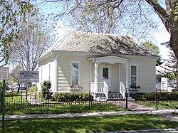 A small house sits by a sign reading "Historic site, Mamie Doud Eisenhower Birthplace, Museum and Library"