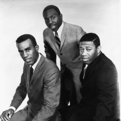The three singers wearing suits