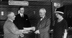 Millikan receives a check for over $40,000 for winning the Nobel Prize, 1924.