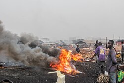 A metal scrap worker is pictured burning insulated copper wires for copper recovery at Agbogbloshie, Ghana.