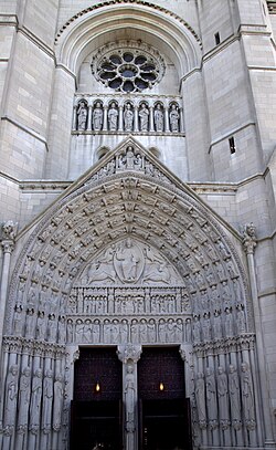 Front doorway at the base of the tower. At the bottom are archivolts (directly under the arch), tympanum, and jambs (bottom, to either side of the doors). At the top is the circular rose window, and niches with the sculptures of seven kings.
