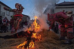 People dressed up as Caretos leap around a bonfire during the Entrudo.
