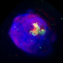 Supernova remnant LMC N 63A imaged in x-ray (blue), optical (green) and radio (red) wavelengths. The X-ray glow is from material heated to about ten million degrees Celsius by a shock wave generated by the supernova explosion.